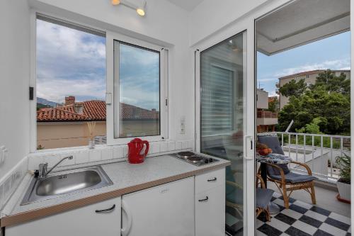 a kitchen with a sink and two windows at Apartment Mediteraneo in Makarska