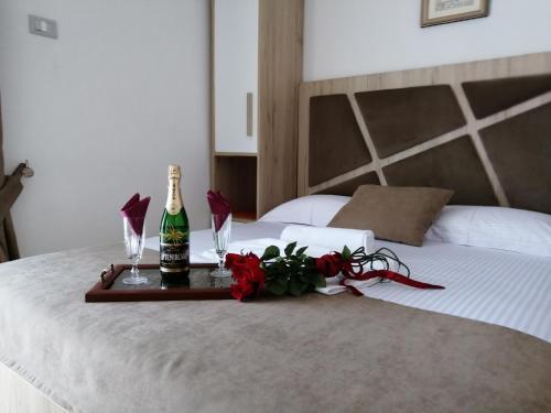 a tray with a bottle of champagne and flowers on a bed at Apartments Gazi in Ulcinj