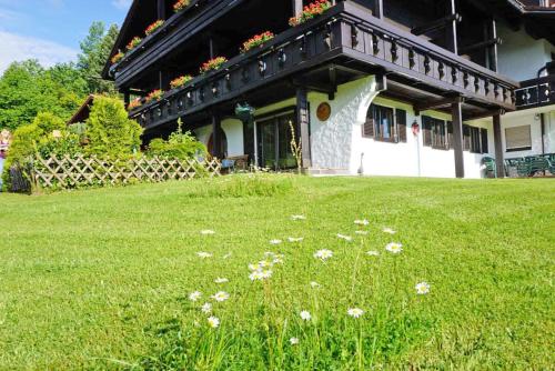 a house with a balcony with flowers on it at Der Sonnenhof - Ferienwohnungen in Obermaiselstein