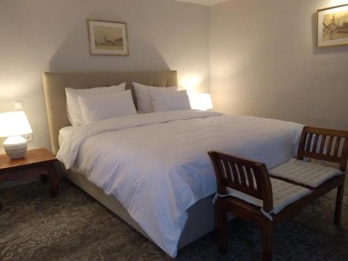 a bedroom with a large white bed and a chair at May House Rodinný Historický dom in Modra
