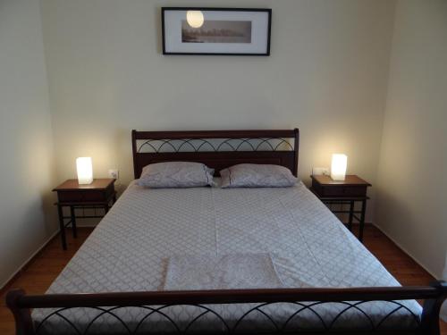 a bedroom with a large bed with two night stands at Estrella Rooms in Nea Kalikratia