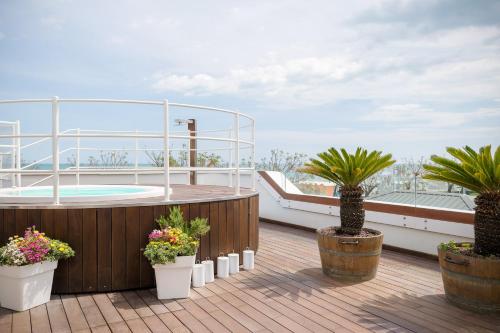 una terraza con bañera de hidromasaje y macetas en un yate en Trampolines Suite Hotel, en Riccione