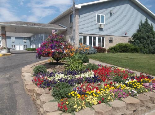 a garden of flowers in front of a house at Governors Inn a Travelodge by Wyndham in Pierre