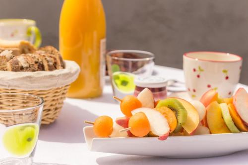 a plate of fruit on a table with a drink at Sous le Cerisier in Venarey-les-Laumes