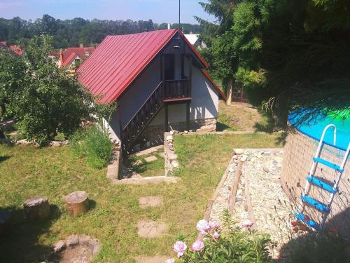 a small house with a red roof and a yard at Chalupa pod zámkem in Mnichovo Hradiště