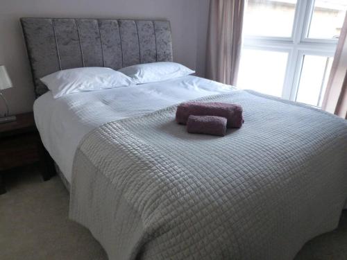 a large white bed with a pillow on it at Shepherds Rest in Kegworth