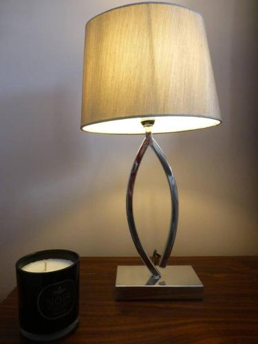una lampada seduta su un tavolo accanto a una candela di Shepherds Rest a Kegworth