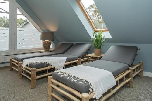 a room with three beds and a window at Upstalsboom Apartments Trassenheide in Trassenheide