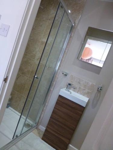 a bathroom with a shower and a sink and a mirror at Shepherds Rest in Kegworth