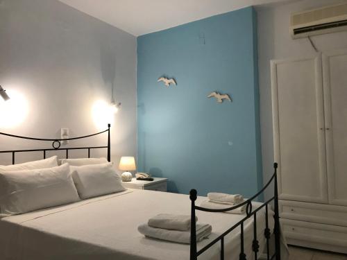a bedroom with a bed with two birds on the wall at Danaides Studios in Batsi