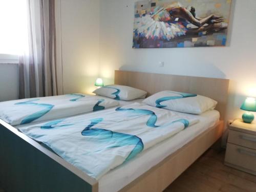 - 2 lits dans une chambre avec des draps et des oreillers bleus dans l'établissement Apartment Juric, à Trogir