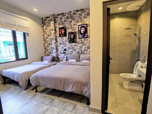 大叻的住宿－Dalat Che House，卧室设有两张床,配有淋浴和卫生间。