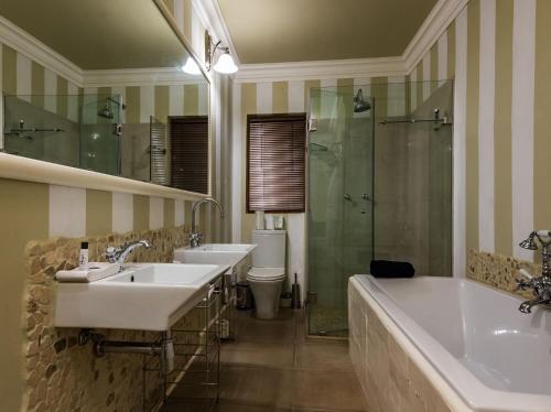 a bathroom with two sinks and a shower at Hagios House in Pretoria