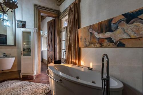 a bathroom with a tub and a painting on the wall at Hagios House in Pretoria
