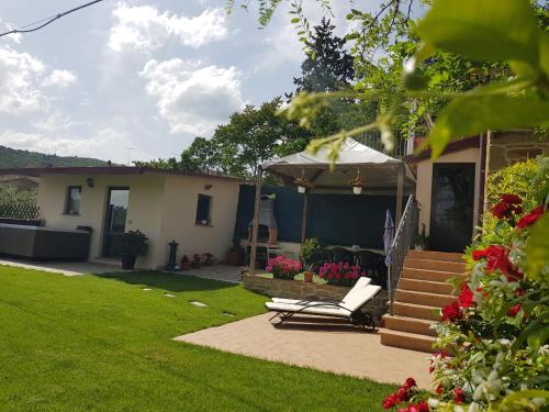 a yard with a house with a chair and a tent at Vicus House in Viciomaggio