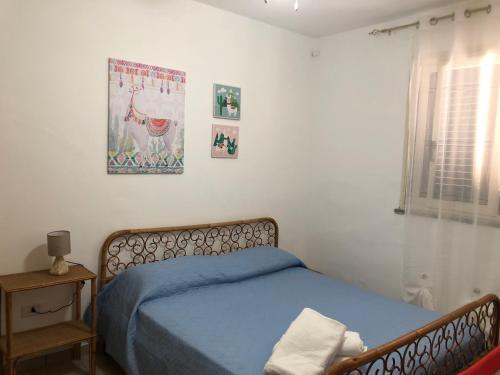 een slaapkamer met een bed en een foto aan de muur bij Martina Casa Vacanze in Marzamemi