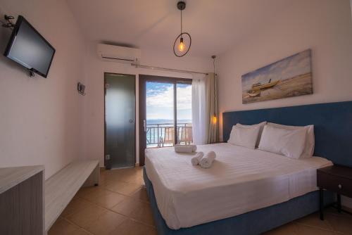 a bedroom with a bed with a television and a window at Barbagiannis House in Ormos Panagias