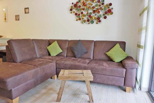 a brown leather couch in a living room with a table at Der Sonnenhof - Ferienwohnungen in Obermaiselstein