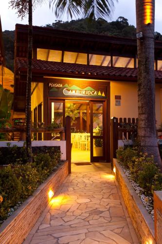 a restaurant entrance with lights in front of a building at Pousada Camburioca in Camburi