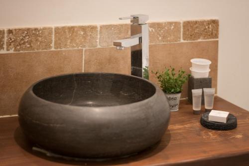 a bathroom with a large black sink on a counter at B&B Maison d'hôte et gite Mas d'Eymard in Arles