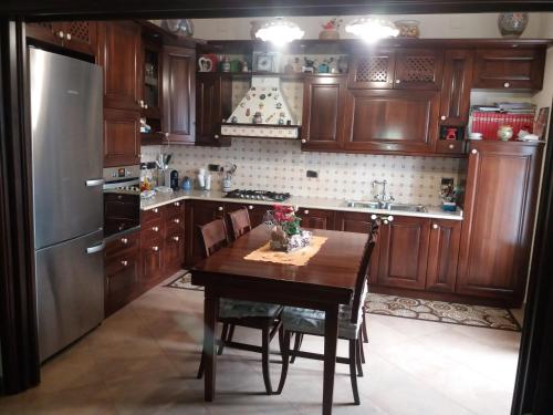 a kitchen with a wooden table and a refrigerator at Villino Maria - Beach Lodge in Torre Faro