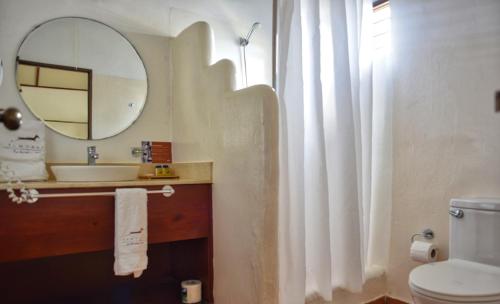 a bathroom with a sink and a mirror and a toilet at El Morro Eco Adventure Hotel in San Fernando de Monte Cristi