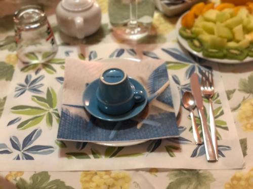 a table with a blue teapot sitting on a plate at La marina in Cagliari