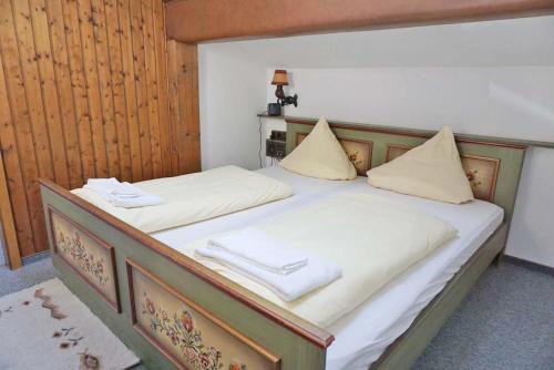a bed with two white towels on top of it at Der Sonnenhof - Ferienwohnungen in Obermaiselstein