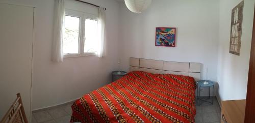 ロス・カーニョス・デ・メカにあるCasa Montecote Playaのベッドルーム1室(オレンジ色の毛布付きのベッド1台付)