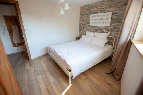 - une petite chambre avec un lit et un mur en briques dans l'établissement Le gîte des Histoires, à Kientzheim
