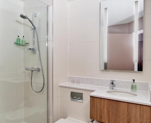 a bathroom with a shower and a sink at Leonardo Edinburgh Murrayfield in Edinburgh