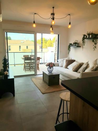 a living room with a couch and a table at T2 NEUF AVEC TERRASSE - PROCHE DES PLAGES in Saint-Cyr-sur-Mer