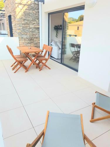 d'une terrasse avec une table et des chaises en bois. dans l'établissement T2 NEUF AVEC TERRASSE - PROCHE DES PLAGES, à Saint-Cyr-sur-Mer