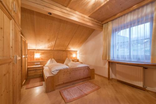 um pequeno quarto com uma cama e uma janela em Residence Lusina em Luson