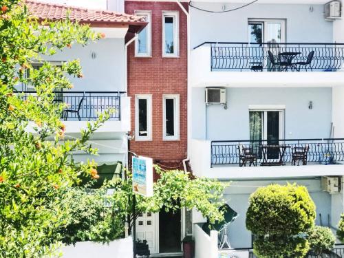 a row of houses with balconies and trees at Kaplanis House in Neos Marmaras