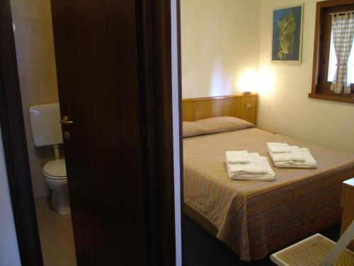 リモーネ・ピエモンテにあるHotel Marguareisのベッドルーム1室(ベッド1台、タオル2枚付)