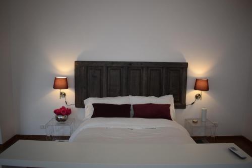a bedroom with a large white bed with two lamps at House System in Giarre