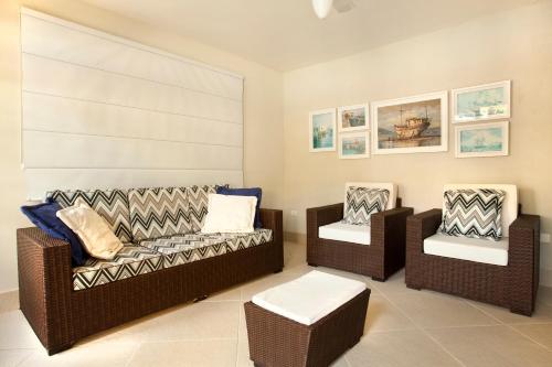 a living room with two chairs and a couch at Pousada Camburioca in Camburi