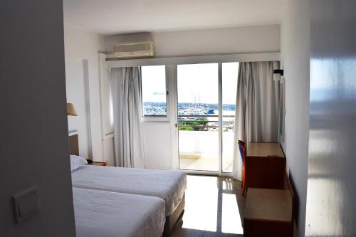 a hotel room with a bed and a large window at Sun Hall Beach Hotel Apartments in Larnaka