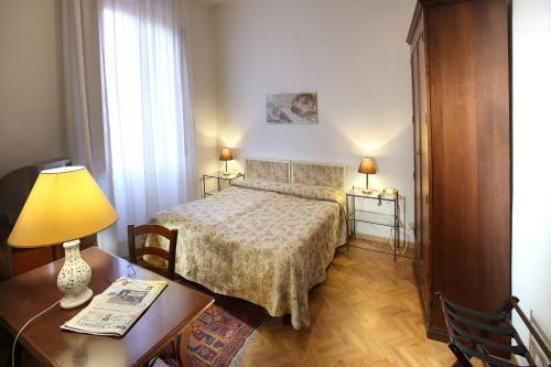 1 dormitorio con 1 cama y 1 mesa con lámpara en Hotel Internazionale, en Montecatini Terme