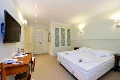 肯傑任科茲萊的住宿－香草別墅酒店，一间卧室配有一张床、一张书桌和一台电视