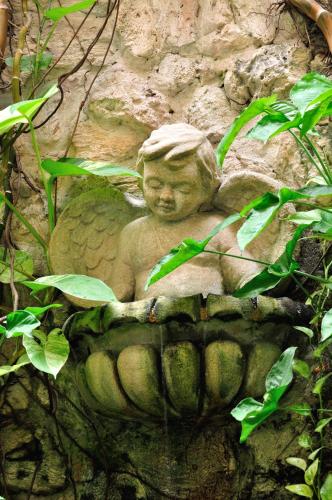 a statue of a little boy sitting on a rock at Hotel Casa La Fe in Cartagena de Indias