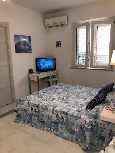 a bedroom with a bed and a flat screen tv at LA MESONETTE A DUE PASSI DAL MARE in Tropea