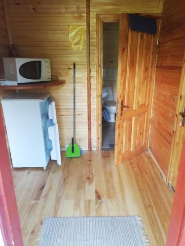 a bathroom with a toilet and a mop in a room at Kempings Mežmalas in Usma