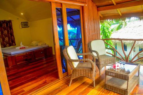 a porch with wicker chairs and a table at Camaya-an Paradise Beach Resort in Malabugas