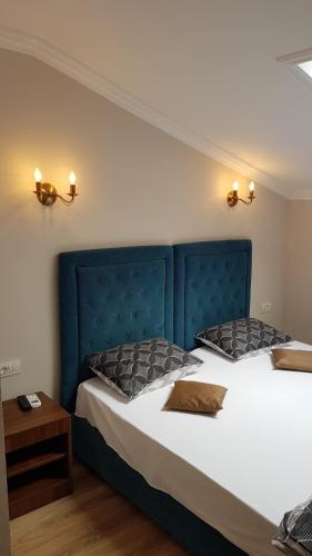 a bedroom with two beds with a blue headboard at Pensiunea La Iani in Constanţa