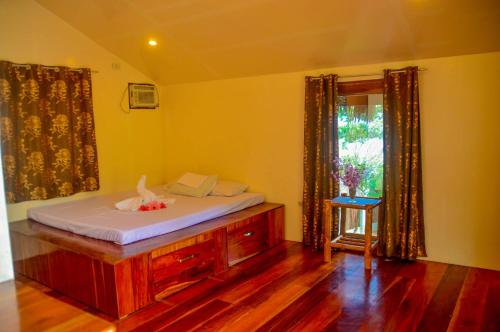 a bedroom with a bed in a room with a window at Camaya-an Paradise Beach Resort in Malabugas