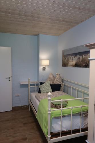 a bedroom with a bed with a green blanket at Ferienwohnung BLAU in Hohenfelde