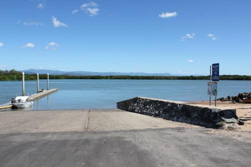 a dock with a boat on a body of water at Seaforth Holiday Units in Seaforth