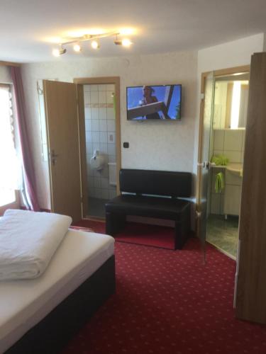 a hotel room with a bed and a tv on the wall at Ferienwohnungen Fellhornblick in Riezlern